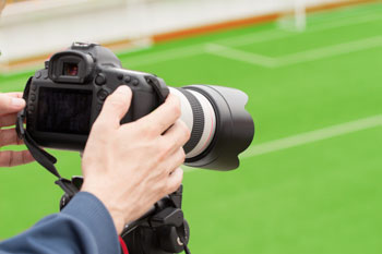 Sportjournalismus Student filmt ein Fußballfeld