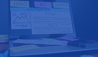 Webdesign Studium Teaser Webdesigner hat auf Monitor die verschiedenen Module einer Webseite mit Papier nachgebaut